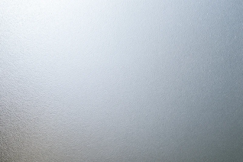 Frosted glass surface with smooth matte texture filling the frame in a flat lay closeup