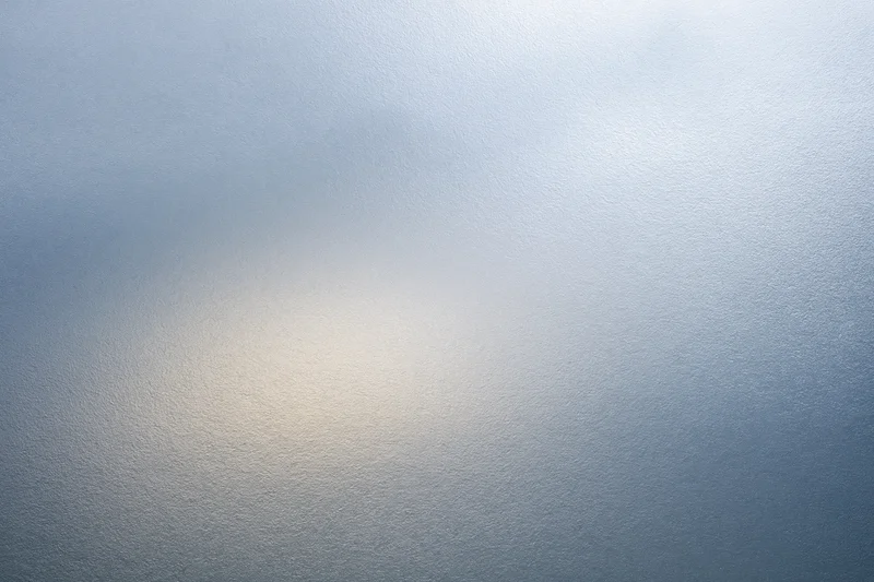 Frosted glass surface with soft light gradient filling the frame