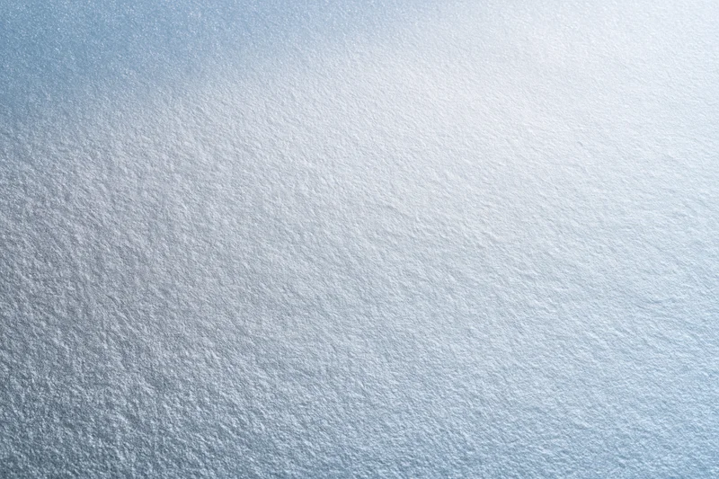 Frosted glass surface in close-up flat lay filling the frame with smooth texture and light gradient
