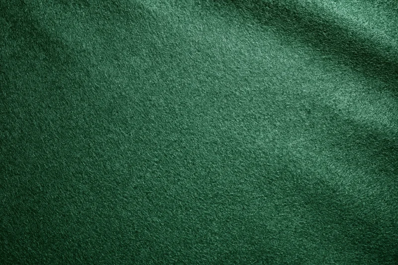 Green casino felt fabric filling the frame in a flat lay close-up view