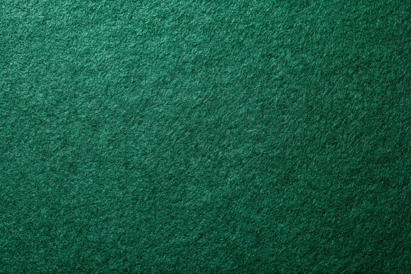Green casino felt fabric filling the frame in a flat lay close-up view