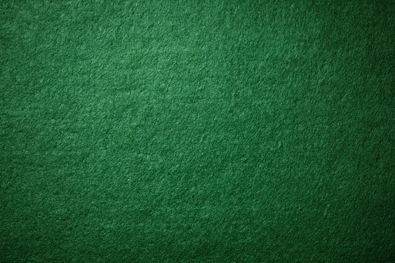 Green casino felt fabric filling the frame in a flat lay close-up view