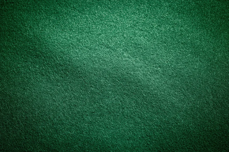 Green casino felt fabric filling the frame in a flat lay close-up view