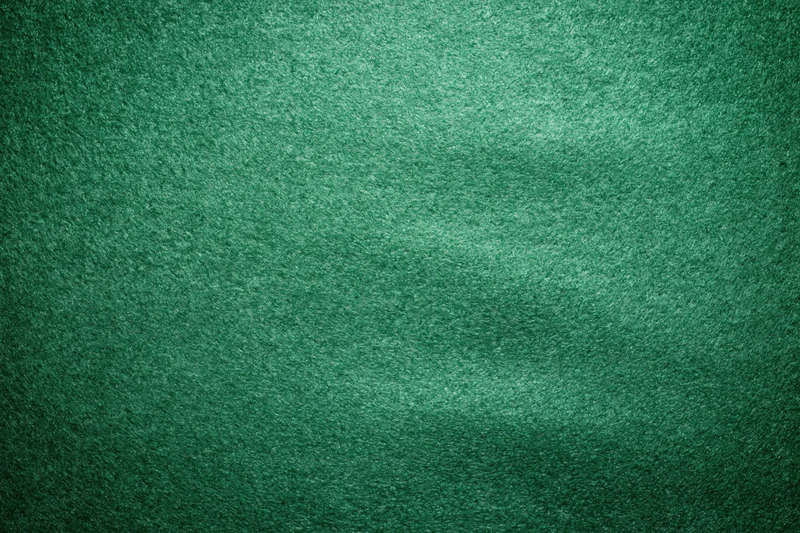 Green casino felt fabric filling the frame in a flat lay close-up view