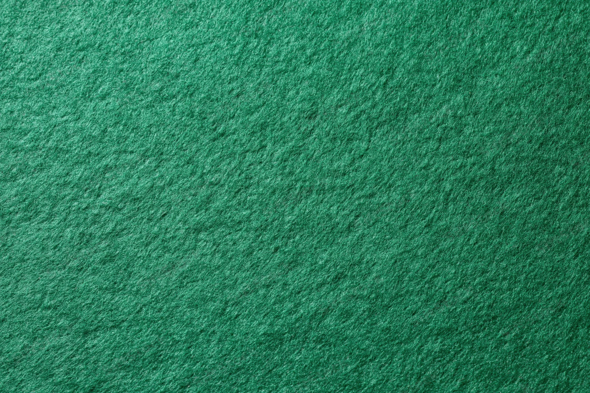 Green felt fabric filling the frame in a flat lay close-up view