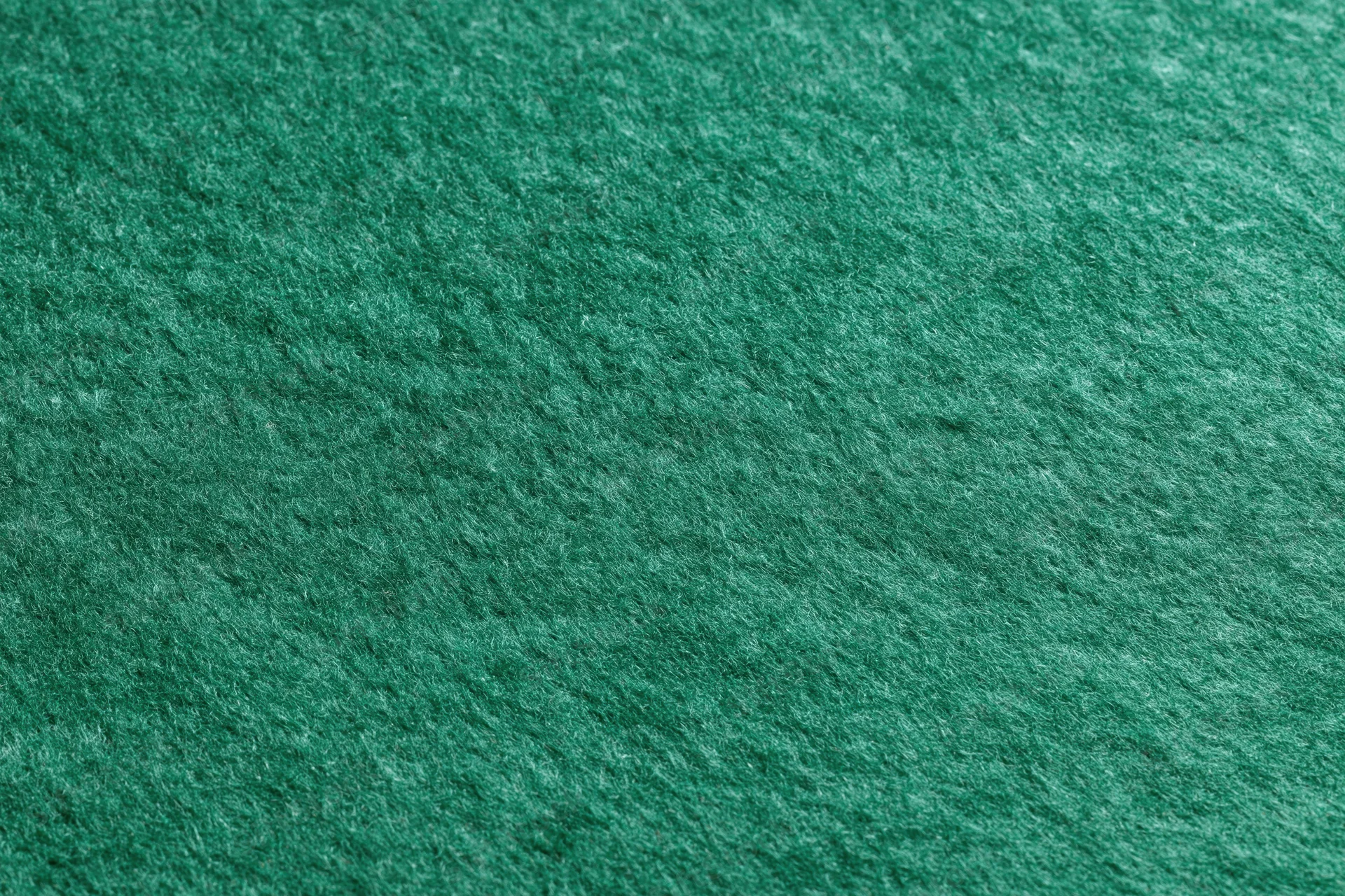 Close-up flat lay of green felt fabric filling the entire frame