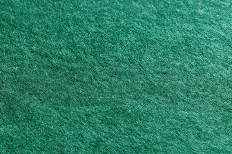Close-up flat lay of green felt fabric filling the entire frame
