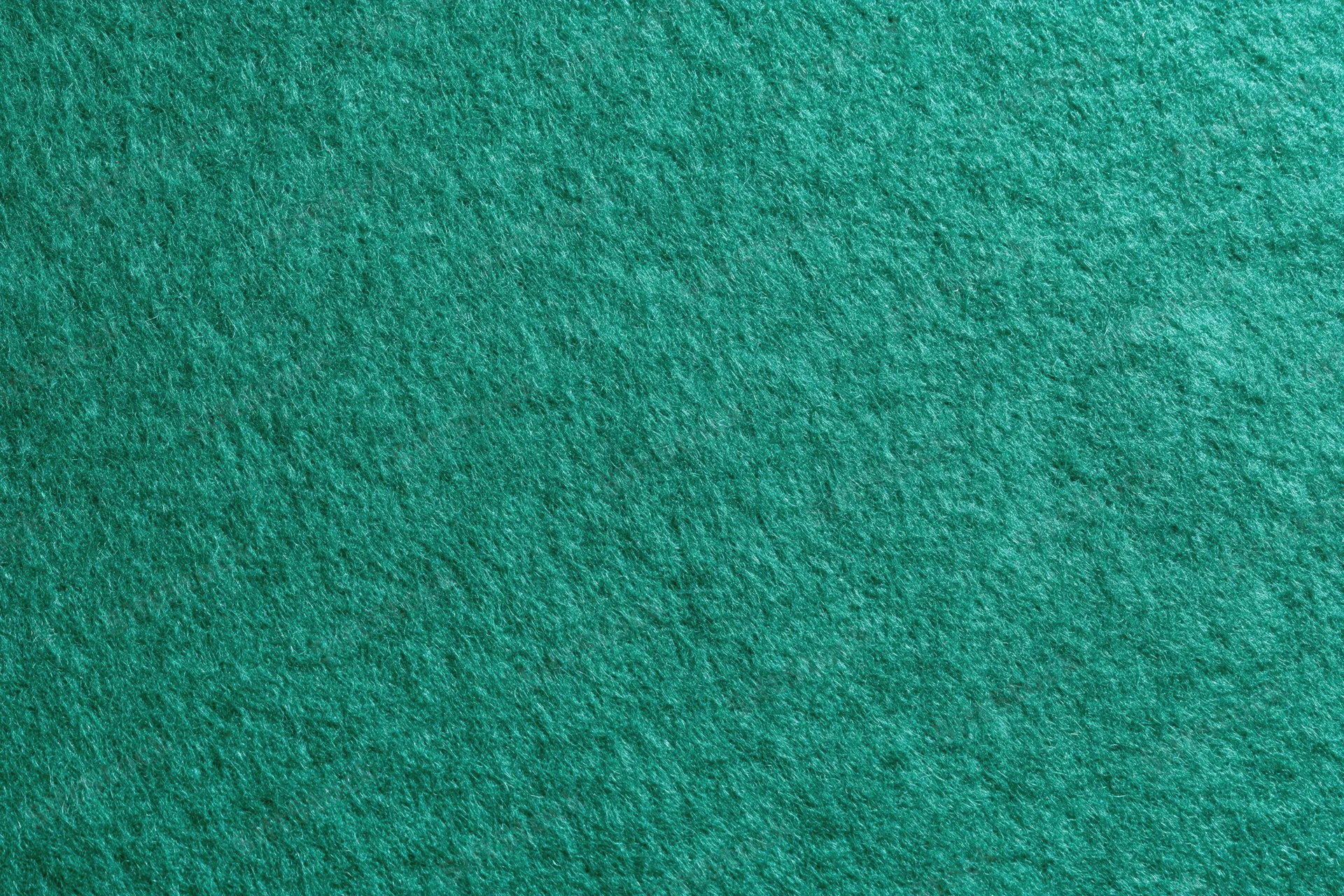 Green felt fabric surface in flat lay closeup filling frame
