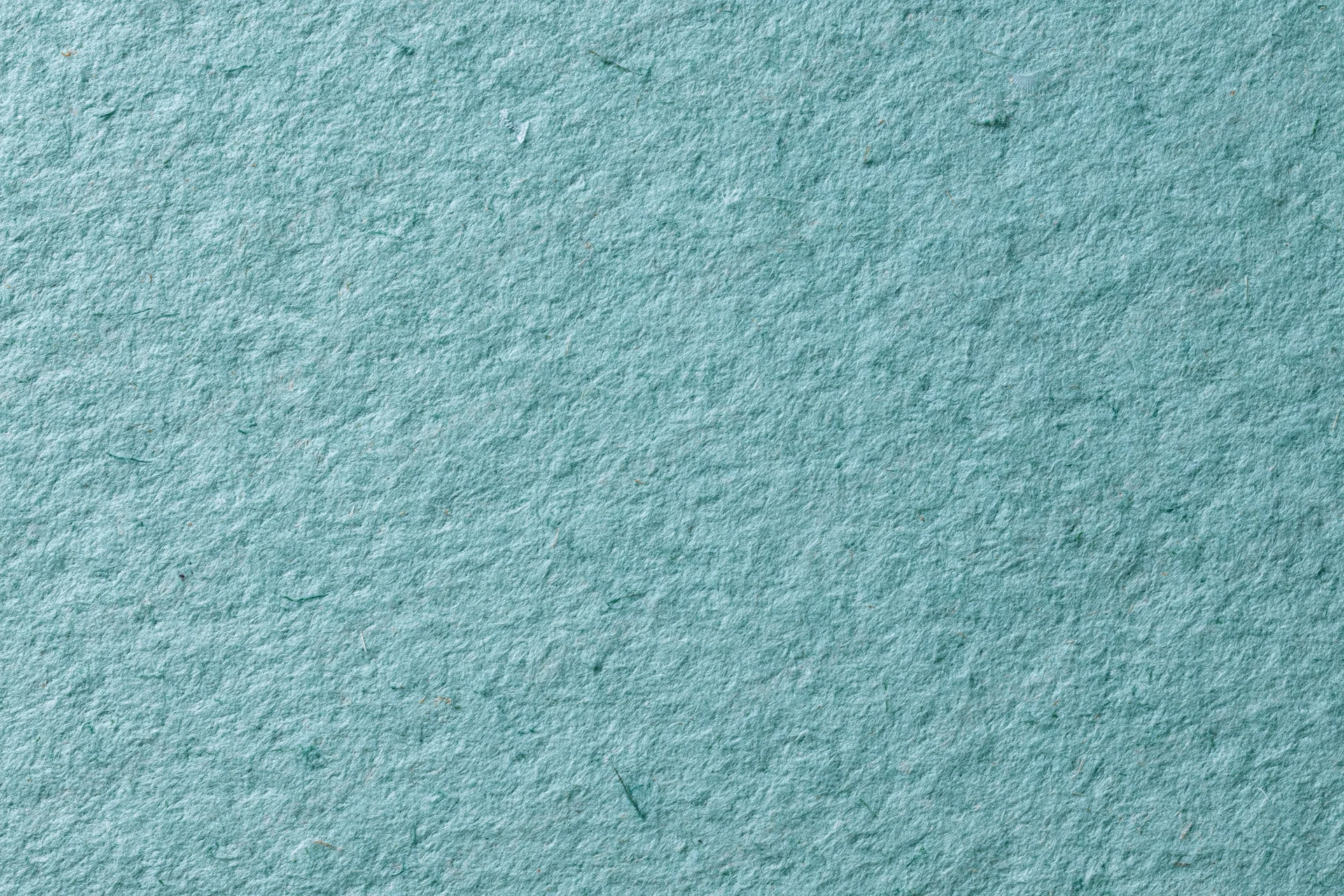 Close-up flat lay of green recycled cardstock paper filling the frame with visible texture and fibers