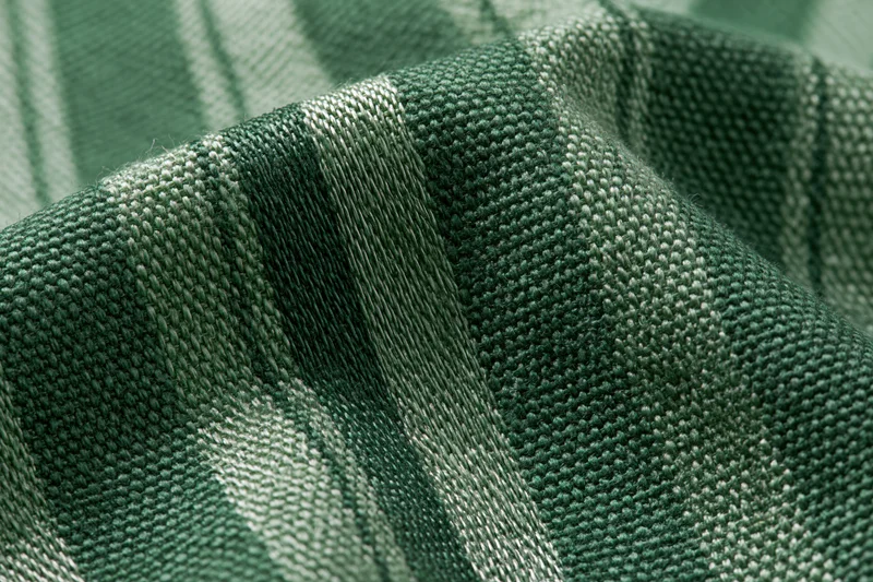 Close-up of green striped woven fabric with checkered pattern filling the frame