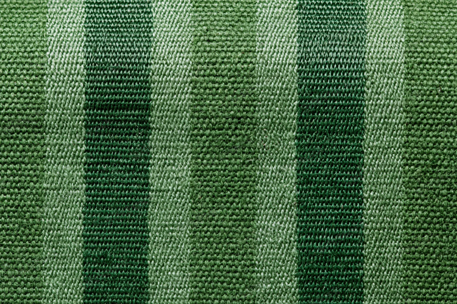 Close-up flat lay of green striped woven fabric filling the frame