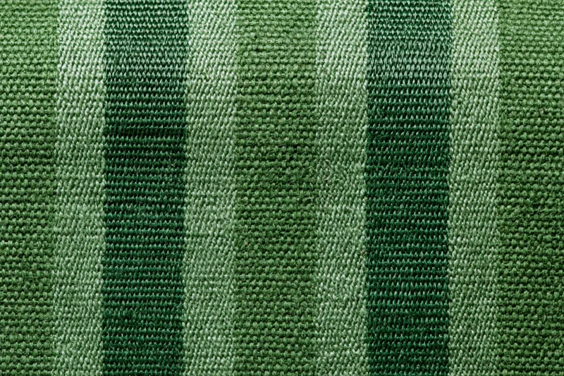 Close-up flat lay of green striped woven fabric filling the frame