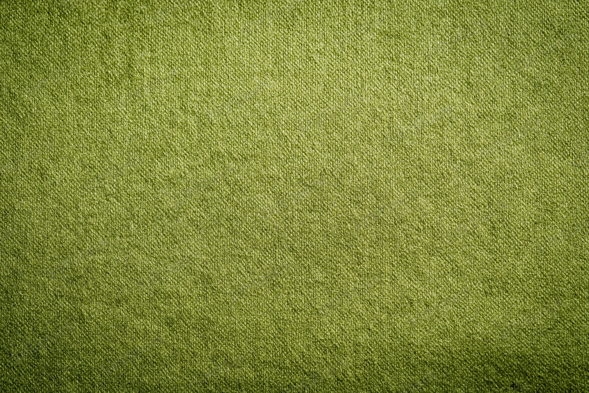 Close-up flat lay of medium-green fabric surface filling the frame