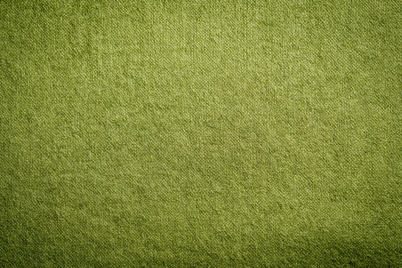 Close-up flat lay of medium-green fabric surface filling the frame