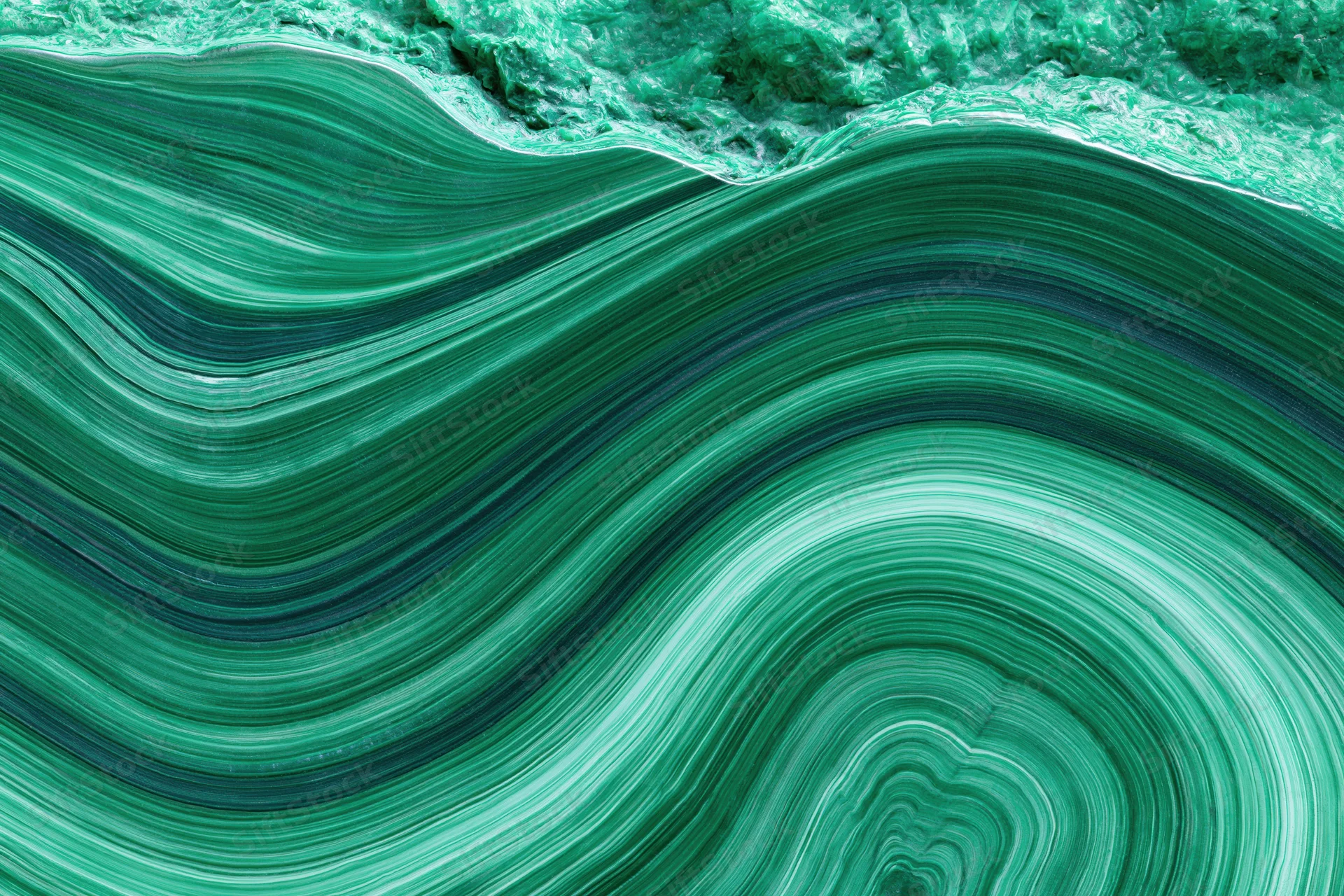 Polished malachite stone surface with concentric green banding filling the frame