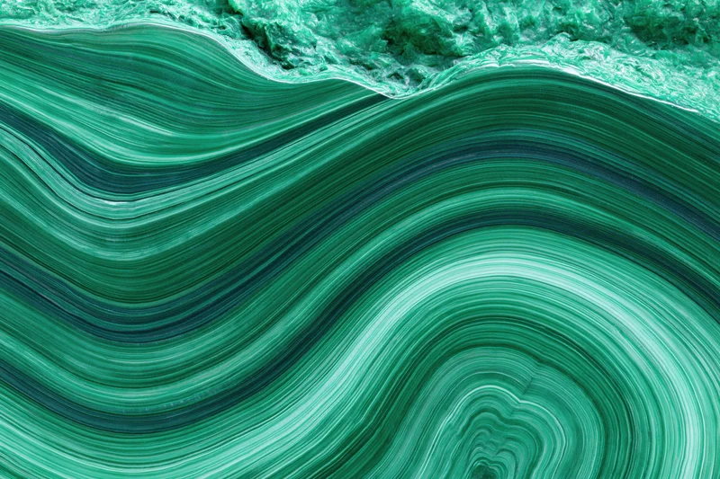 Polished malachite stone surface with concentric green banding filling the frame