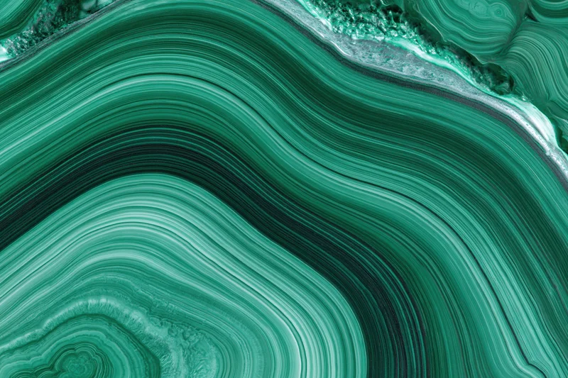 Polished malachite stone surface with concentric green banding in flat lay closeup