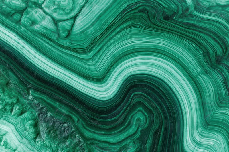 Polished malachite stone surface with swirling green patterns filling the frame