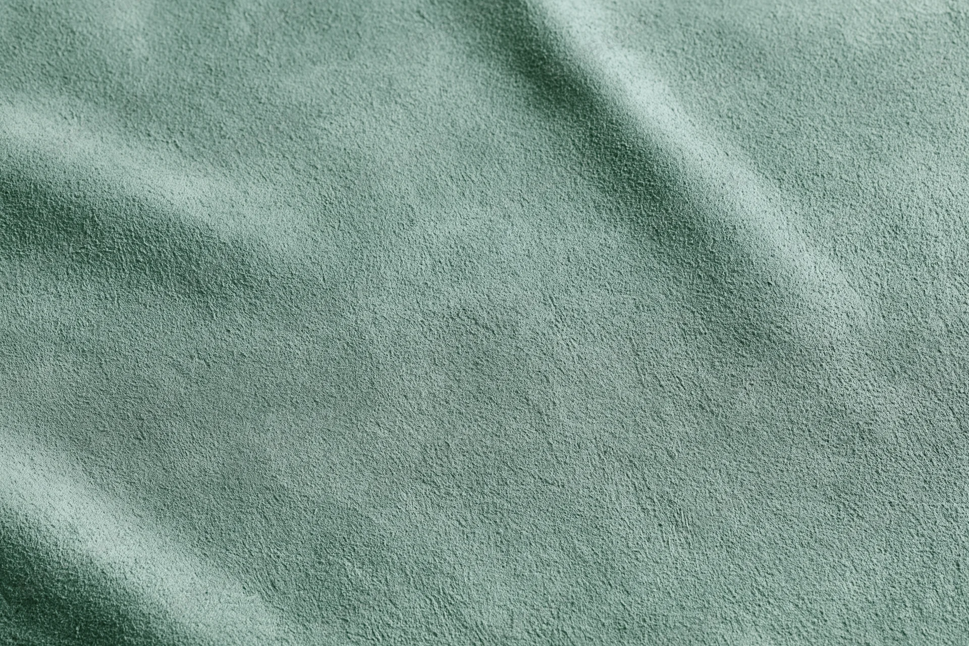 Close-up flat lay of sage green suede or velvet fabric texture filling the frame