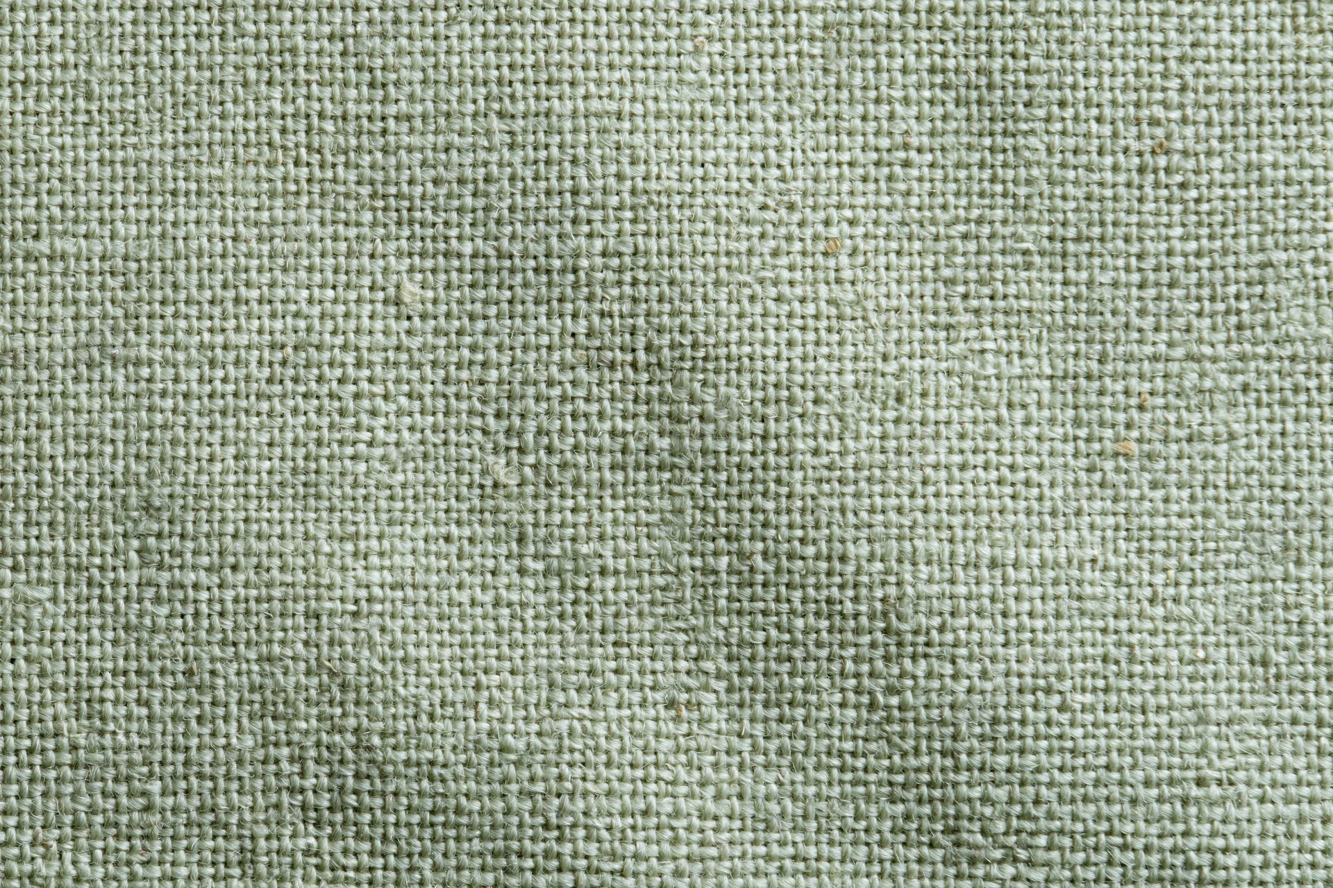 Close-up flat lay of sage green woven fabric texture filling the frame