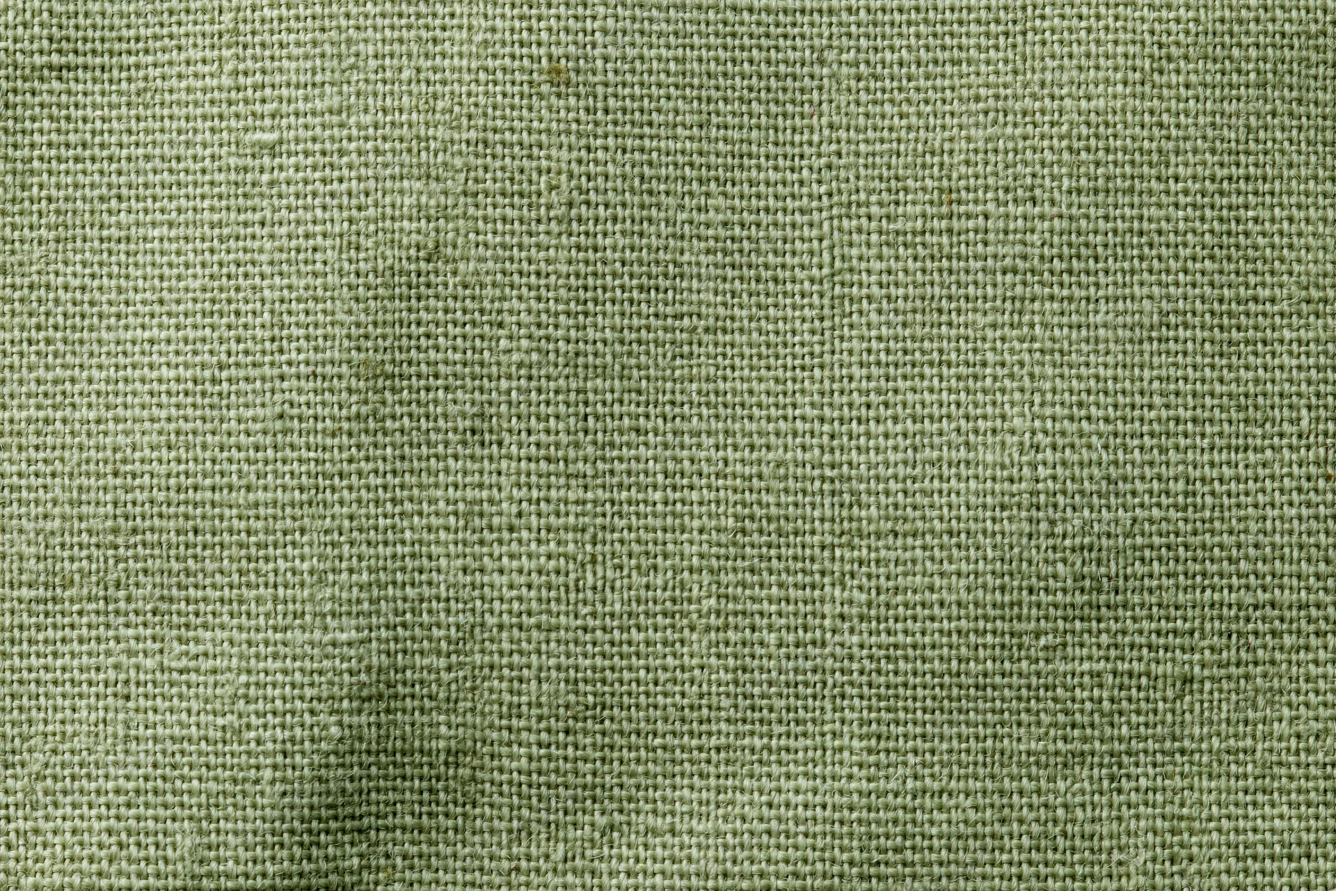 Close-up flat lay of sage green woven fabric texture filling the frame