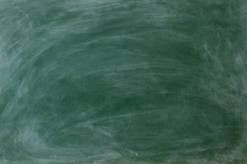 Blank green chalkboard surface with white chalk residue and smudges, no writing visible