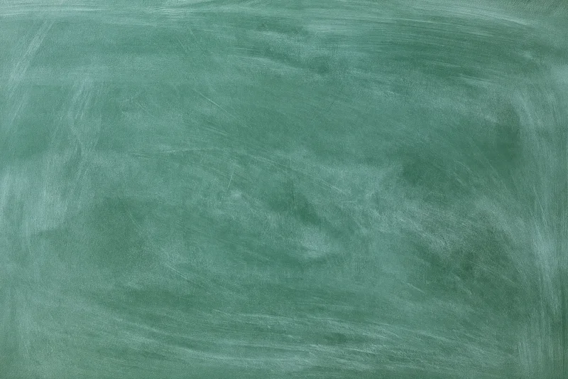 Blank green chalkboard surface with smudged white marks, no writing, flat close-up view