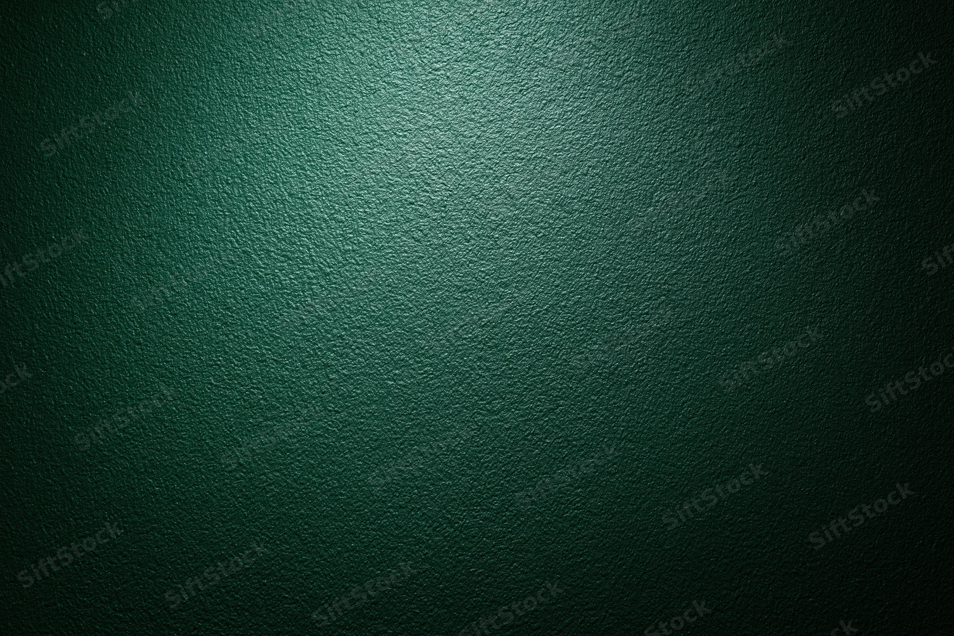 Dark forest green painted wall surface in close-up flat shot with even lighting and subtle texture