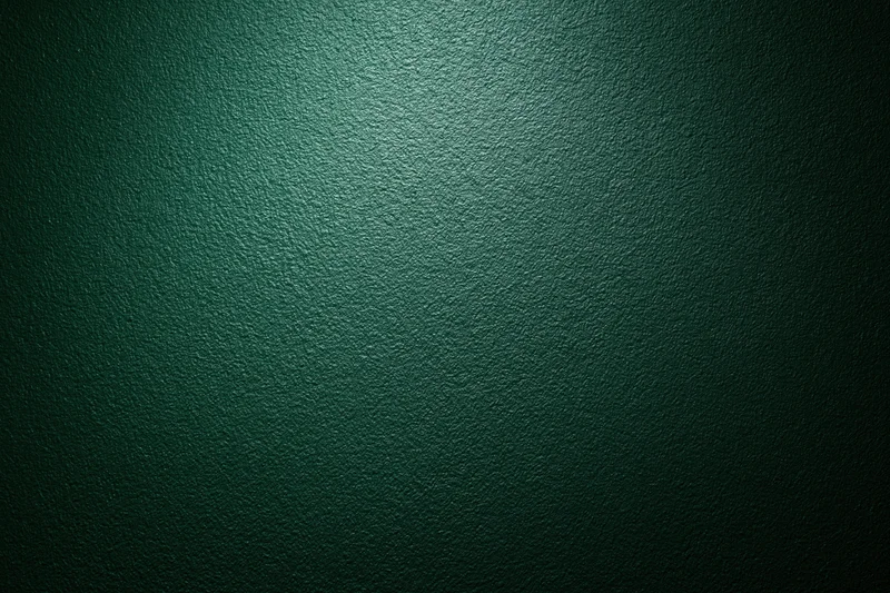Dark forest green painted wall surface in close-up flat shot with even lighting and subtle texture