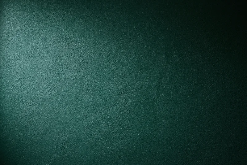 Dark forest green painted wall surface in close-up flat shot with visible texture and subtle lighting gradient