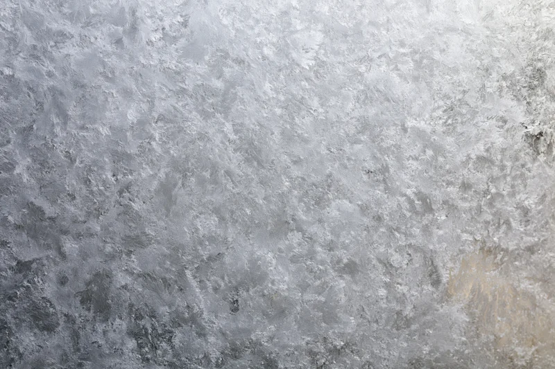 Frosted glass surface with icy texture in close-up flat view