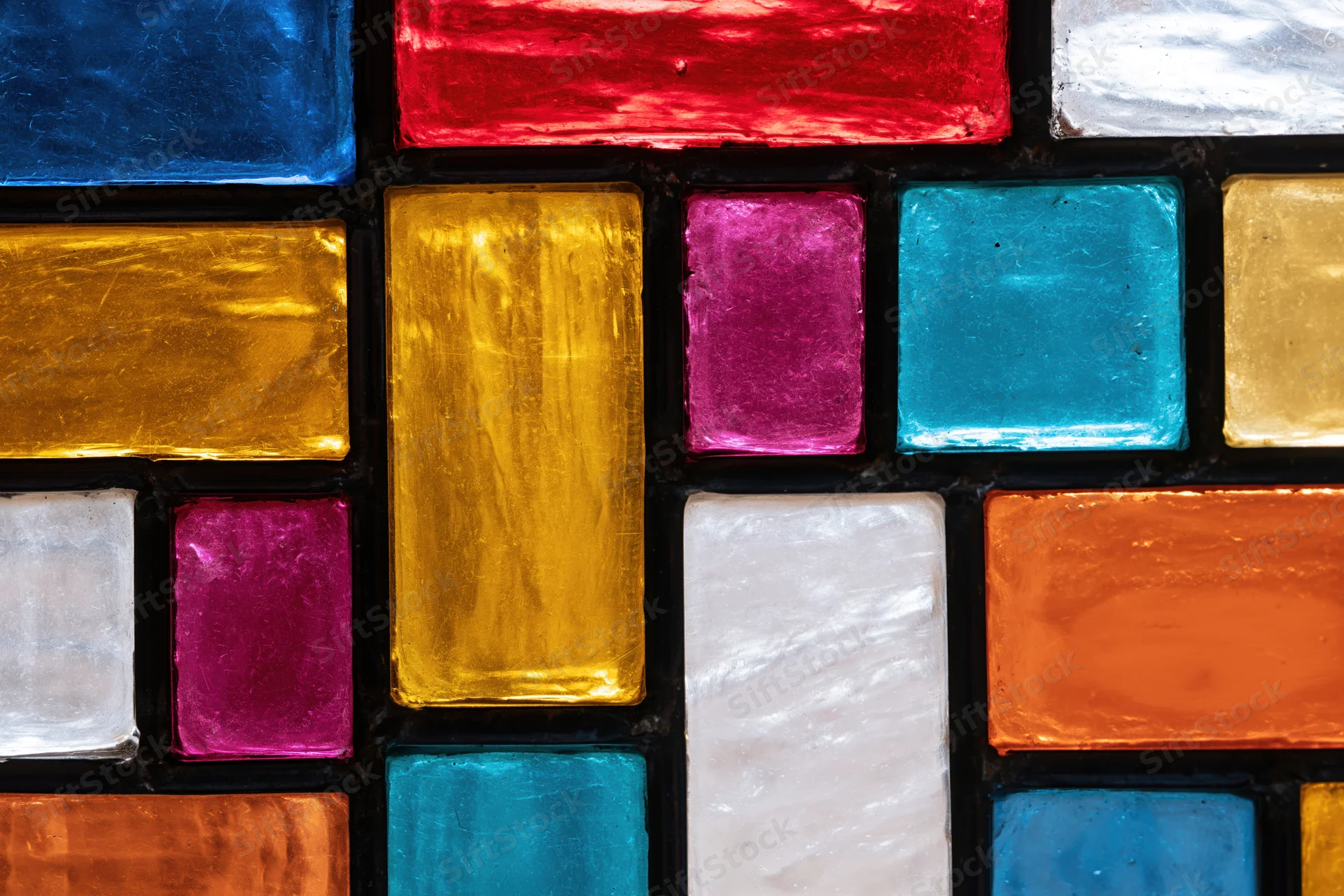 Close-up of a geometric stained glass window with colorful rectangular panels arranged in a mosaic pattern