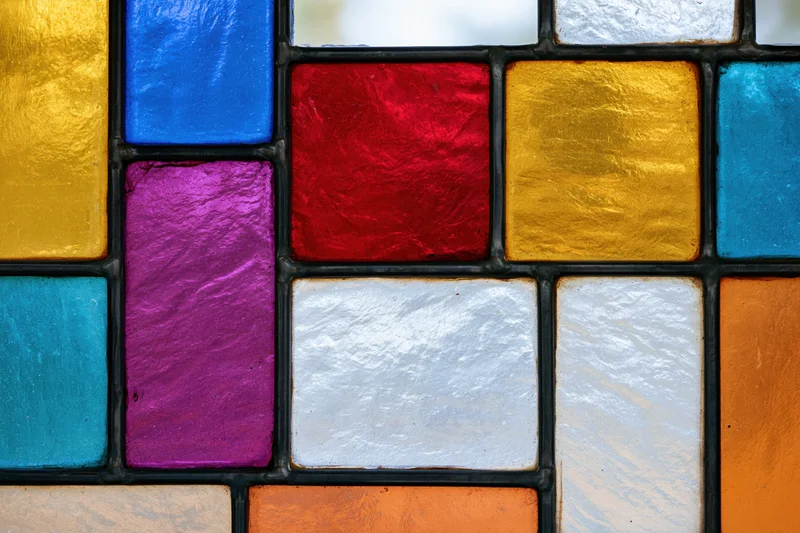 Close-up of a geometric stained glass window with colorful rectangular panels arranged in a grid pattern