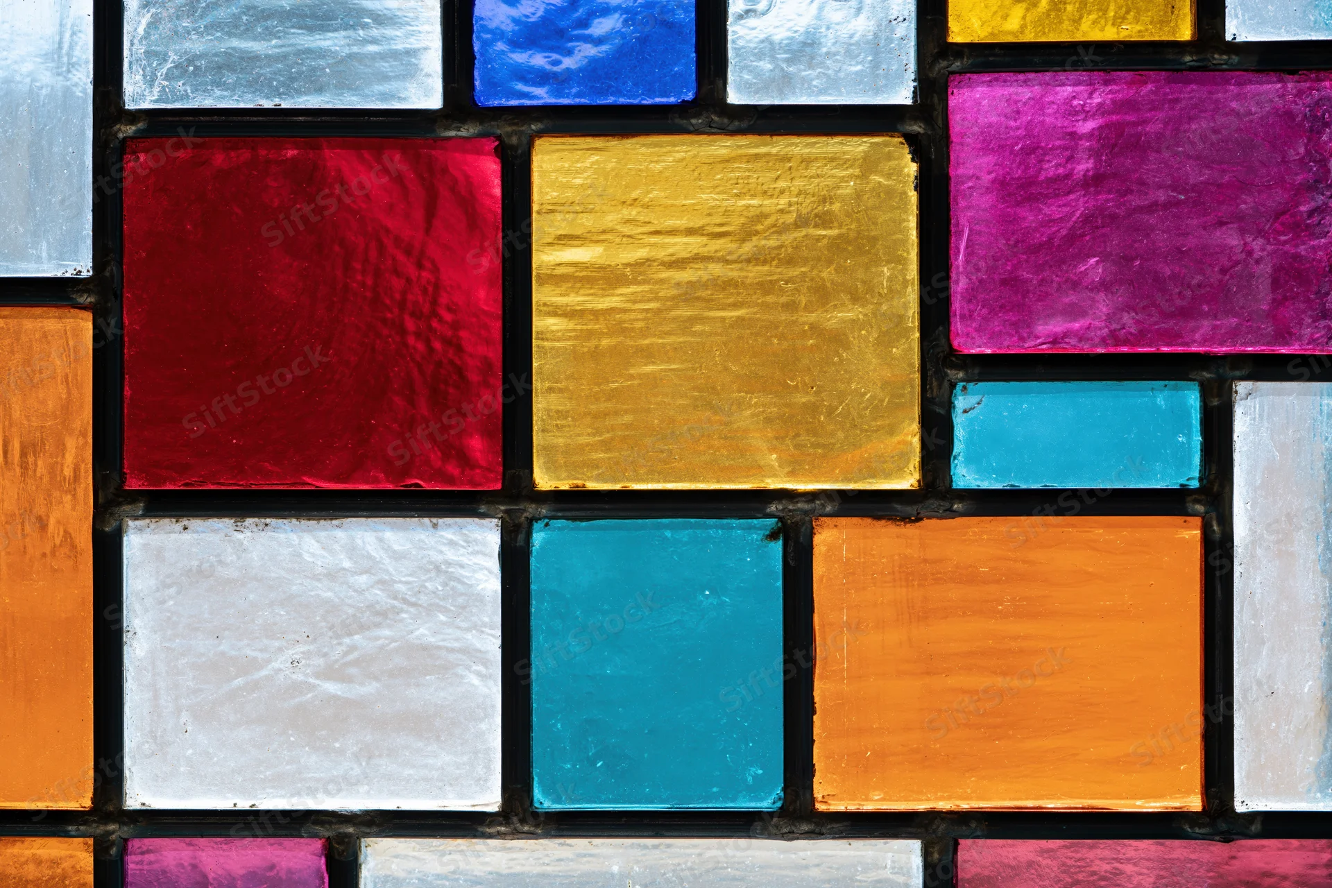 Close-up of a geometric stained glass window with colorful square tiles arranged in a grid pattern