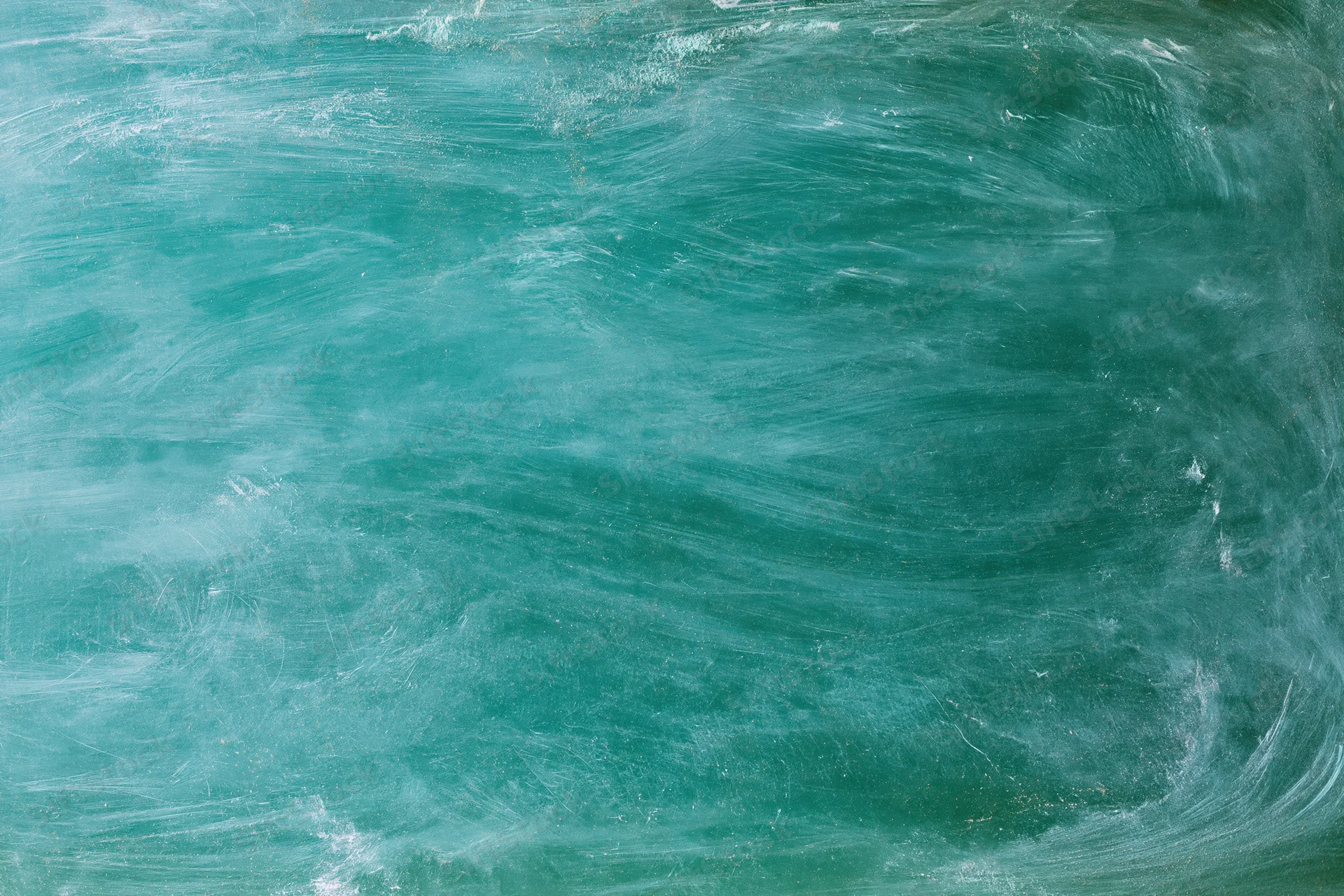 Close-up of a green chalkboard surface with smudged residue and eraser marks, flat overhead view