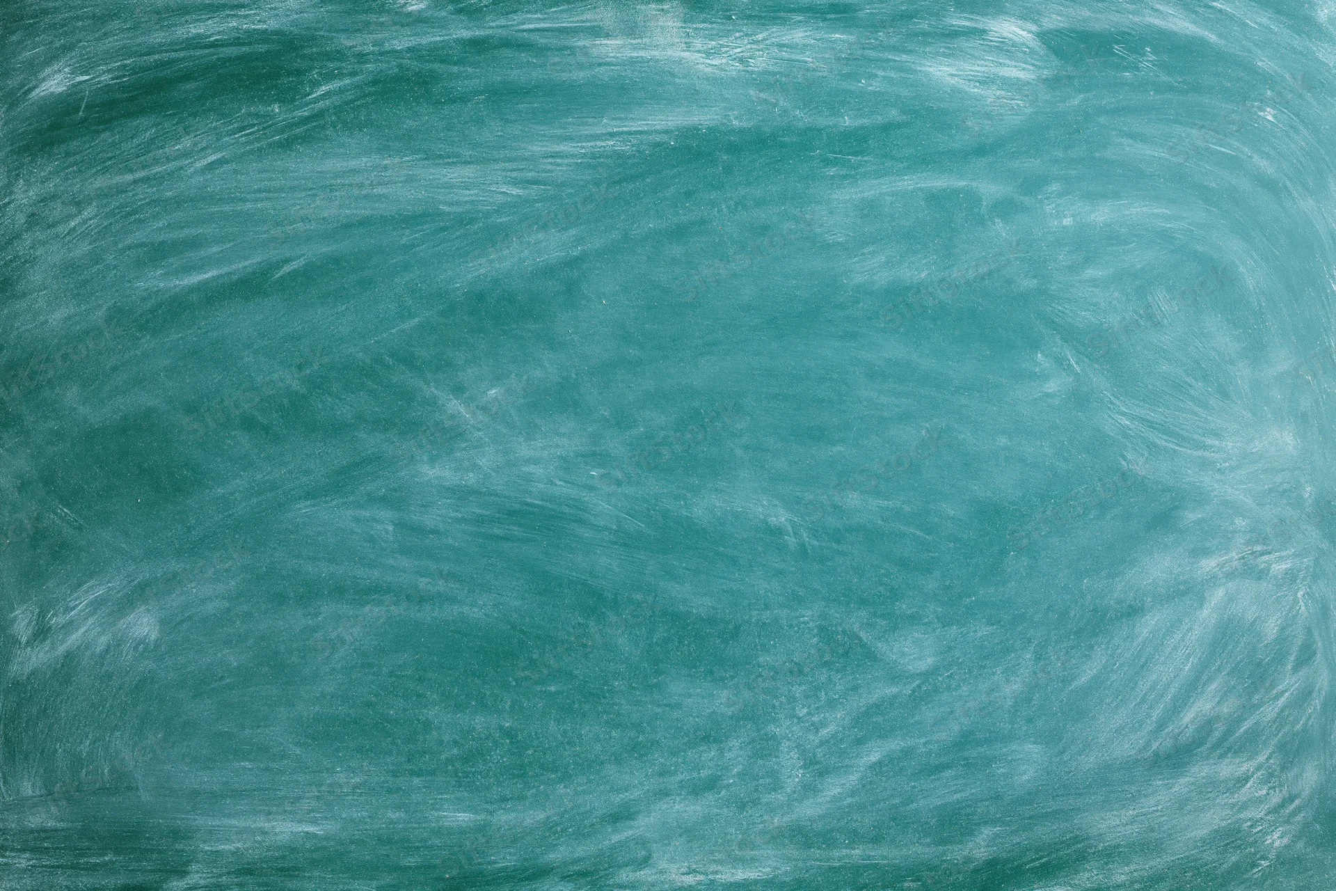 Close-up of a green chalkboard surface with smudged white residue from recent erasing