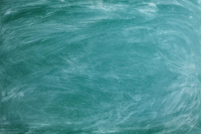 Close-up of a green chalkboard surface with smudged white residue from recent erasing