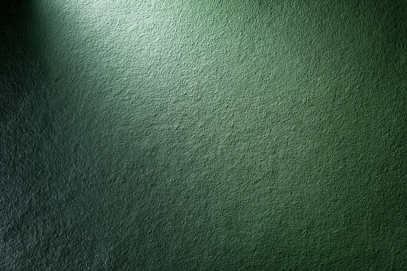 Matte green painted wall surface in close-up flat view