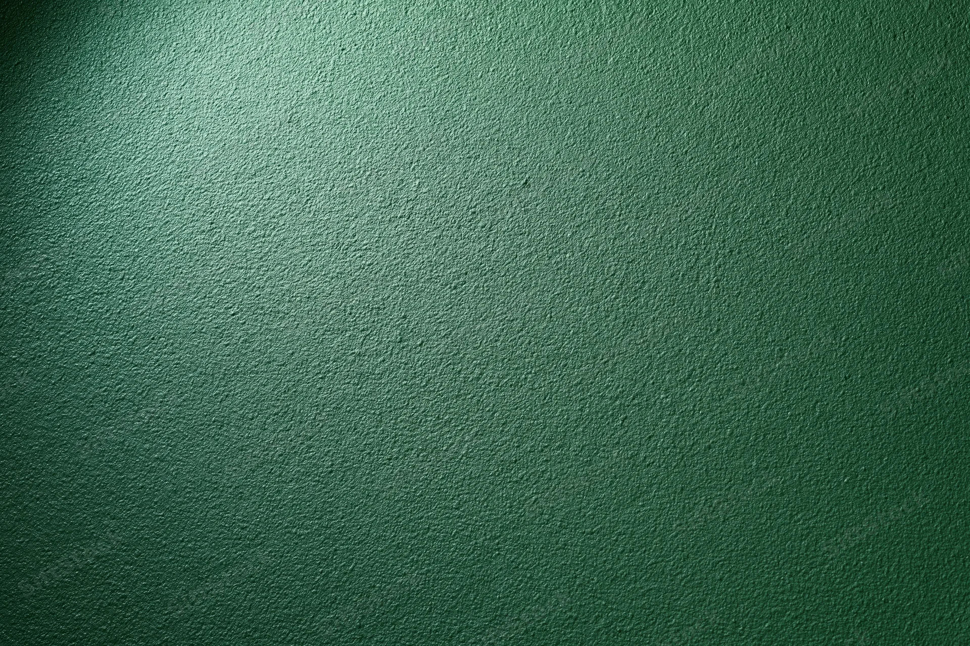 Close-up of a matte green painted wall surface filling the frame