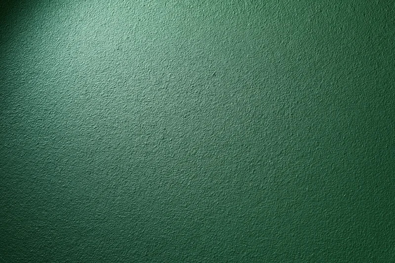 Close-up of a matte green painted wall surface filling the frame