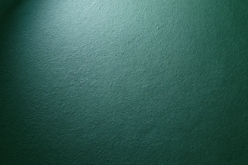 Matte green painted wall surface in close-up flat view