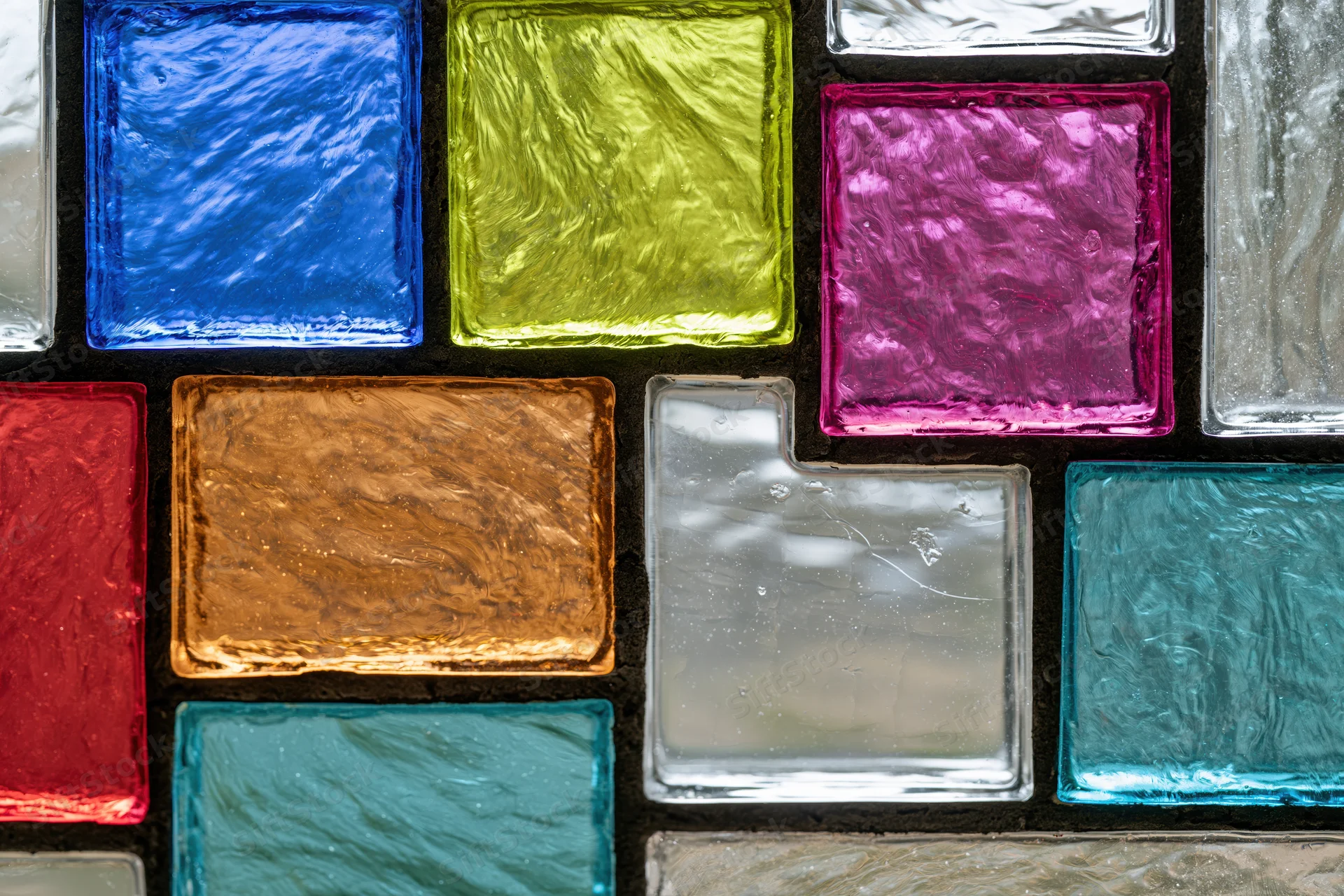 Close-up of a stained glass panel with colorful textured glass squares arranged in a grid pattern