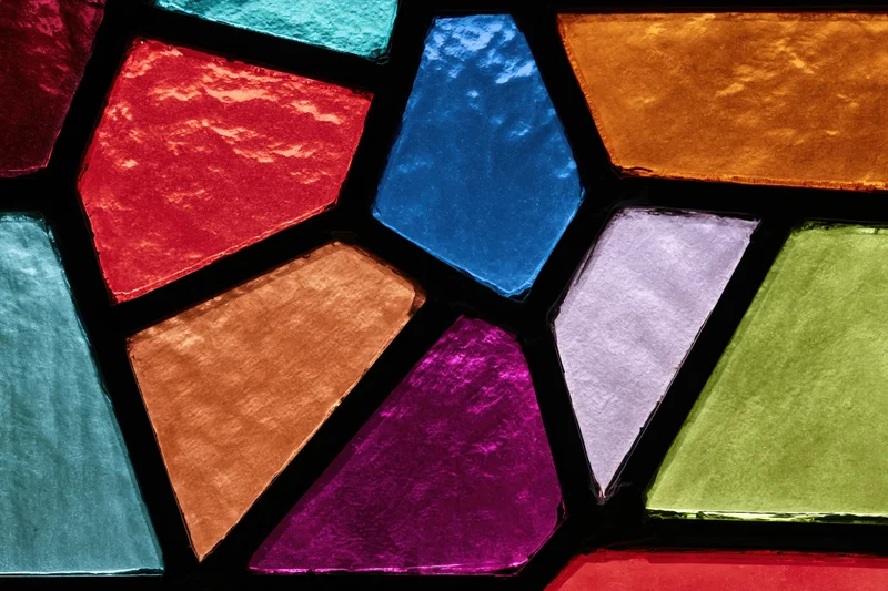 Close-up of a stained glass window with colorful geometric panels arranged in a mosaic pattern