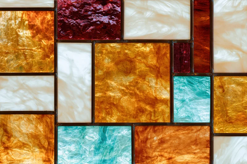 Close-up of a stained glass window panel with colorful translucent glass pieces arranged in a mosaic pattern