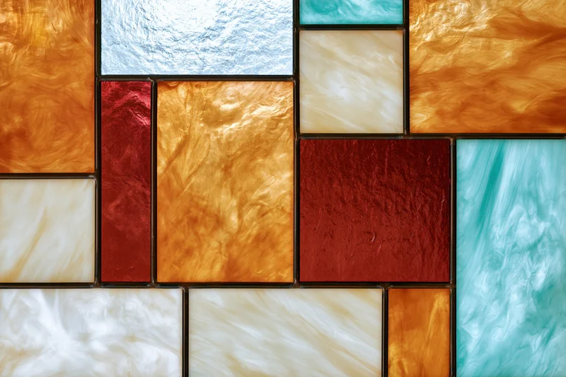 Stained glass window panel arranged in a mosaic pattern with colorful translucent tiles