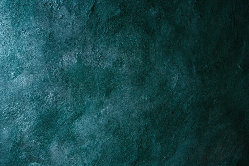Weathered painted wall surface with textured concrete finish in teal blue tones