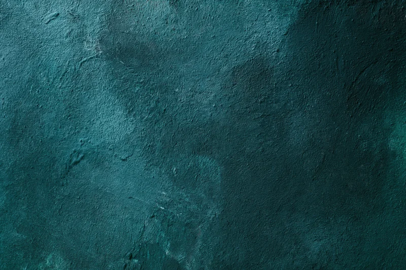 Weathered painted wall surface in teal with textured concrete finish