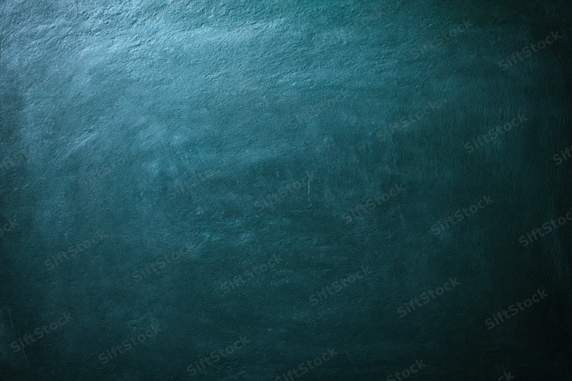Worn chalkboard surface with dark teal texture and smudged marks showing signs of use
