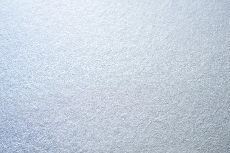 Close-up of frosted glass or matte white painted surface with subtle texture and even lighting