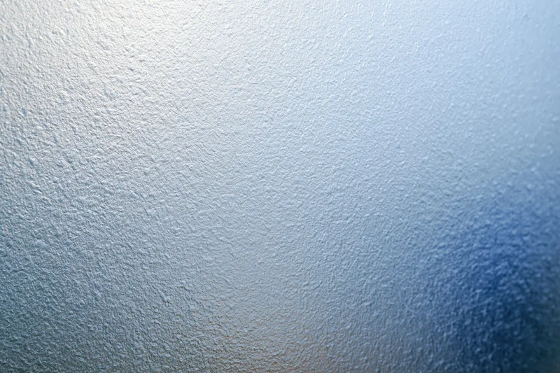 Frosted glass surface with textured pattern and blue gradient background